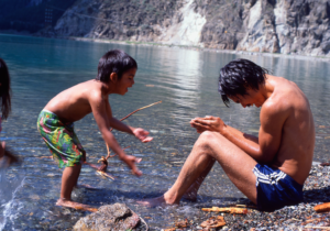 Father playing by the water with his son.