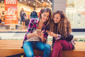 Young women in the mall using credit card for online shopping 